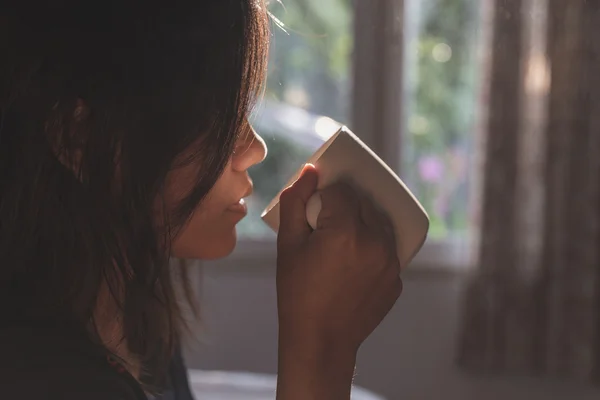 Mujer sosteniendo la taza de café en la mañana, centrarse en la mano — Foto de Stock