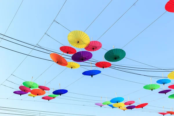 Elektrik kablo ve gökyüzü arka plan üzerinde renkli şemsiye asmak — Stok fotoğraf