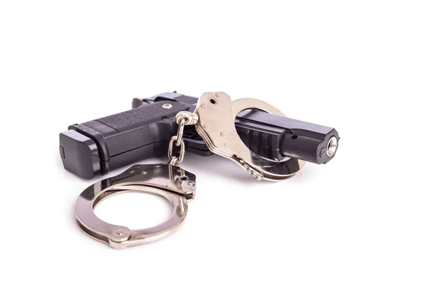 Крупним планом пістолет і наручники ізольовані на білому — стокове фото