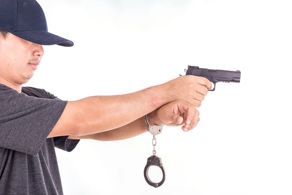 Close up man with handcuffs and gun on hands isolated on white — Stock Photo, Image