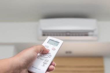 Uzaktan kumanda üzerinde saç kremi yönetmen tutan el