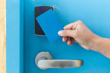 Mavi otel keycard elektrikli kapı önünde tutan el