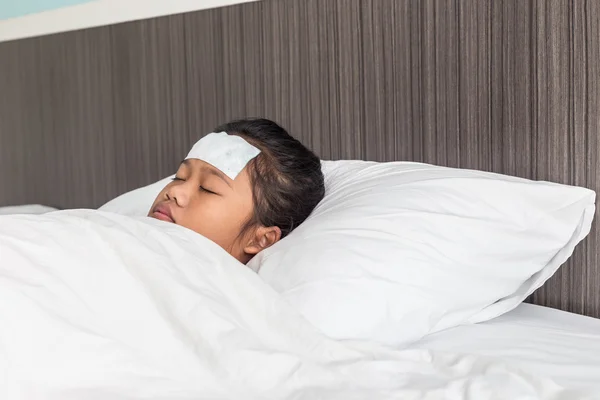 Niños con fiebre fría en la frente y durmiendo en la cama — Foto de Stock