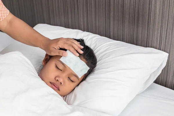 Niños con fiebre fría en la frente y durmiendo en la cama — Foto de Stock