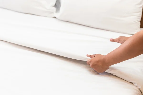 Mano establecer sábana blanca en la habitación de hotel — Foto de Stock