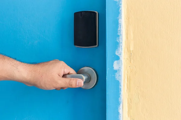 Hand som håller på rostfritt stål dörrhandtag i hotel — Stockfoto