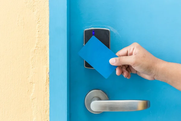 Ruka držící keycard blue hotel přední elektrické dveře — Stock fotografie