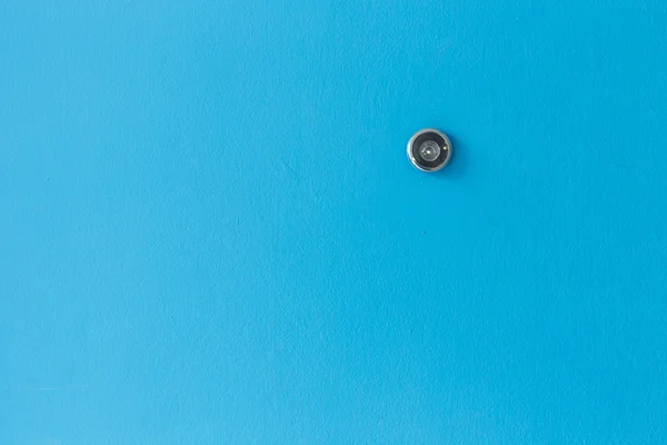 Peephole lentille de porte sur texture en bois bleu — Photo