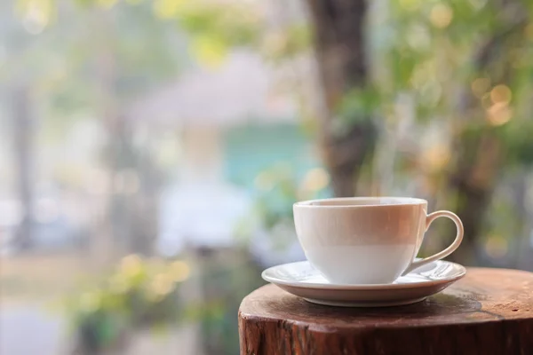 ぼかし光ボケ味を持つ庭でテーブルの上の白いコーヒー カップ — ストック写真
