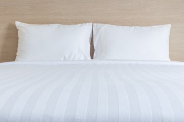 Beyaz çarşaf ve yastık otel odasında yatak takımları