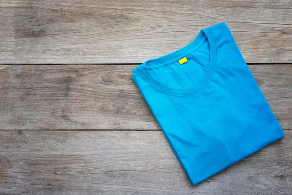 ท็อปวิวของเสื้อยืดสีบนกระดานไม้สีเทา — ภาพถ่ายสต็อก