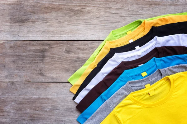 Top view of color T-Shirt on grey wood plank — Stock Photo, Image