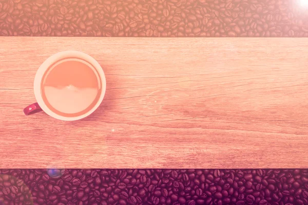 Koffiekopje en koffiebonen op houten achtergrond, Focus op kop — Stockfoto