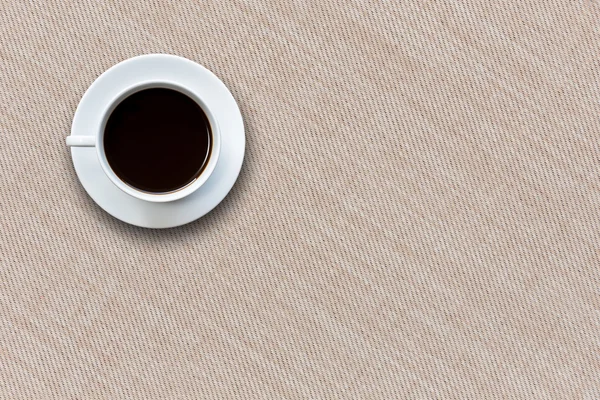 Weiße Kaffeetasse auf Stoff Hintergrund von oben — Stockfoto