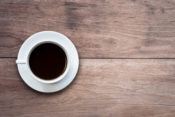 White coffee cup on wooden table top view 