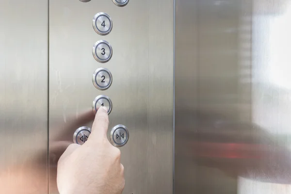 Hand drückt silbernen Fahrstuhlknopf — Stockfoto