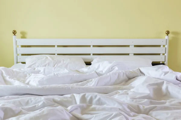 Белые простыни и подушки, грязная концепция кровати — стоковое фото