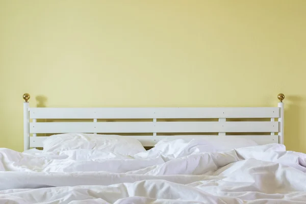 Lençóis brancos e travesseiro, conceito de cama bagunçada — Fotografia de Stock