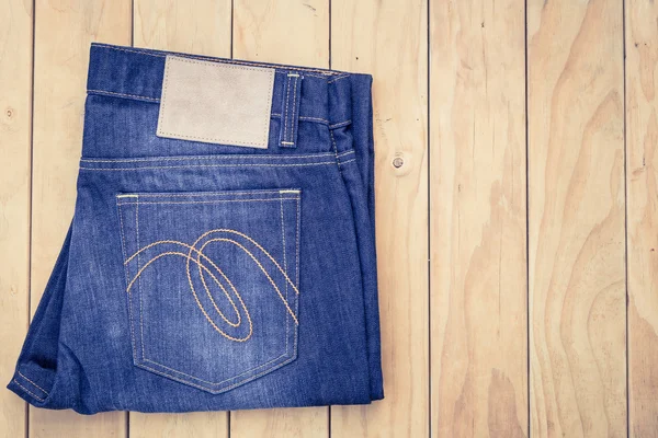 Mavi jeans ahşap arka plan üzerinde görünümü top