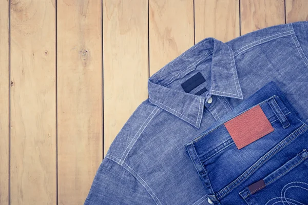 Синие джинсы на деревянном фоне — стоковое фото