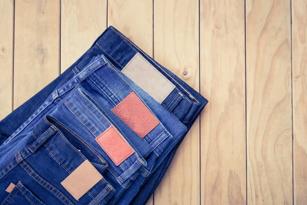 Blue jeans on wooden background top view — Stock Photo, Image