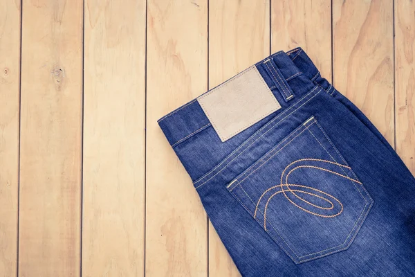 Mavi jeans ahşap arka plan üzerinde görünümü top