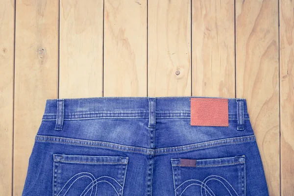 Mavi jeans ahşap arka plan üzerinde görünümü top