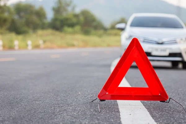 Red emergency stop sign and broken car on the road — Stock Photo, Image