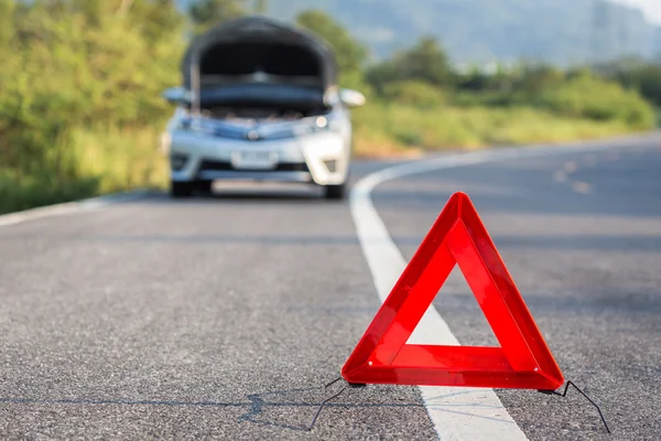 Czerwony awaryjny znak stopu i zepsuty samochód na drodze — Zdjęcie stockowe