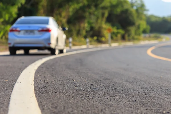 Niewyraźne odwrocie nowy srebrny samochód, parking przy drodze asfaltowej — Zdjęcie stockowe