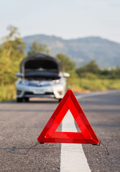 Segnale rosso di arresto di emergenza e auto rotta sulla strada — Foto Stock