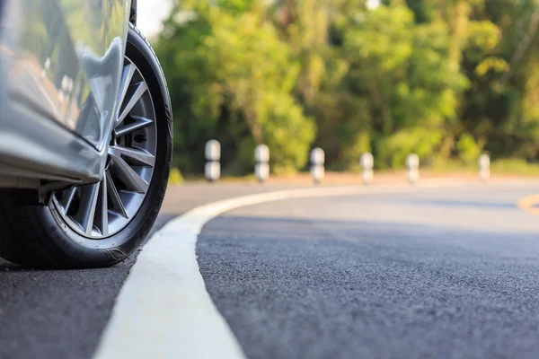 Front car wheel on the asphalt road — Stock Photo, Image