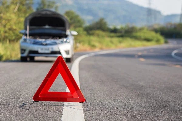 Panneau rouge d'arrêt d'urgence et voiture cassée sur la route — Photo