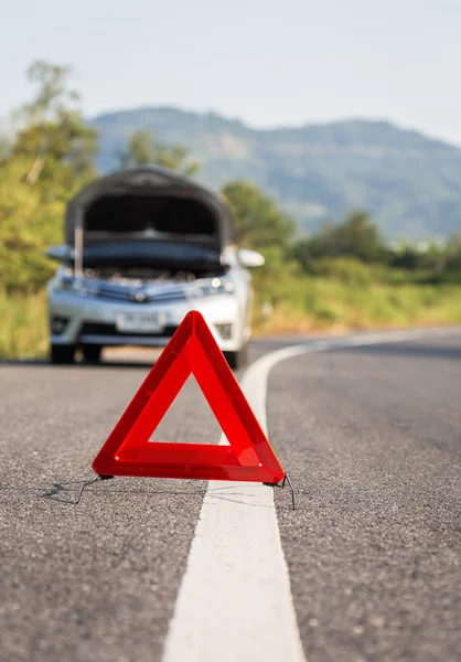 Czerwony awaryjny znak stopu i zepsuty samochód na drodze — Zdjęcie stockowe