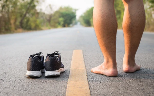 Legs of man with black running shoes on asphalt road in morning — Stock Photo, Image