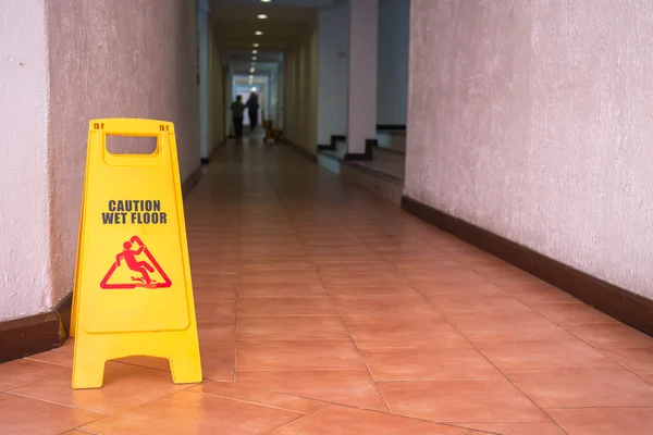 在酒店走廊的地板上的警告标志 — 图库照片