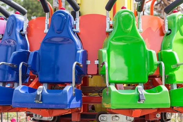 Coloridos asientos de montaña rusa en el parque de atracciones — Foto de Stock