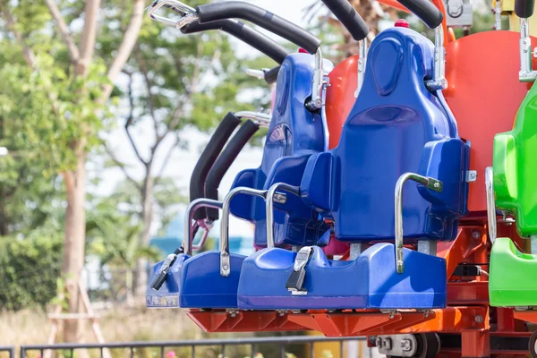 Coloridos asientos de montaña rusa en el parque de atracciones — Foto de Stock