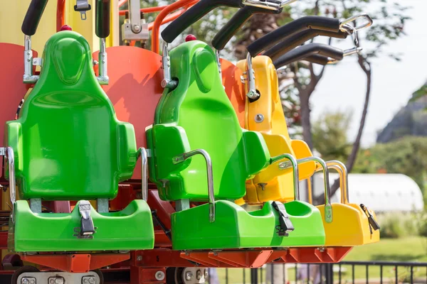 Coloridos asientos de montaña rusa en el parque de atracciones — Foto de Stock