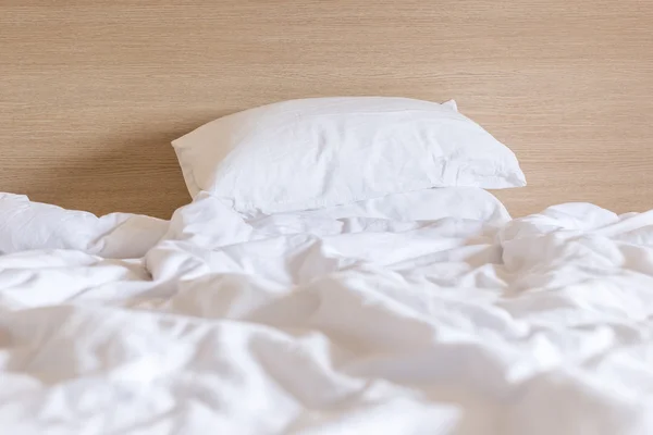 Sábanas blancas y almohada, concepto de cama desordenado —  Fotos de Stock