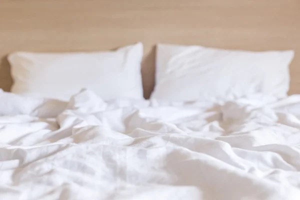 Sábanas blancas y almohada, concepto de cama desordenado —  Fotos de Stock