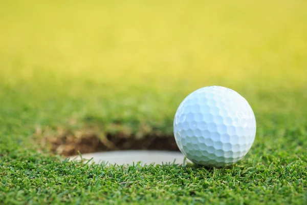 Pelota de golf en el labio de la taza en curso — Foto de Stock