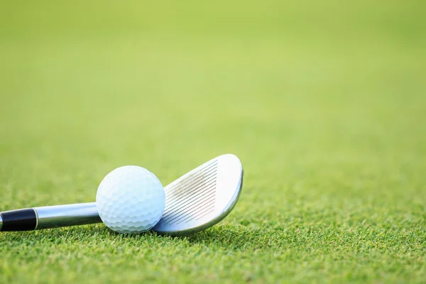 Golfbal op groen gras in cursus — Stockfoto