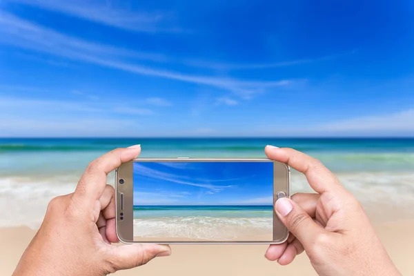 Mano de mujer sosteniendo el teléfono inteligente y tomar una foto de la vista —  Fotos de Stock