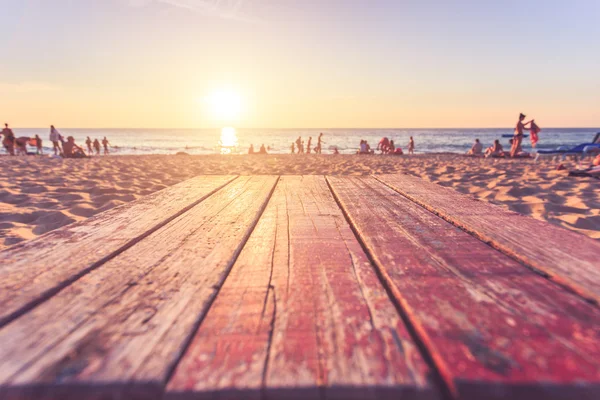 Top of wooden table at sunset beach with lens flare. Warm toning — Stock Photo, Image
