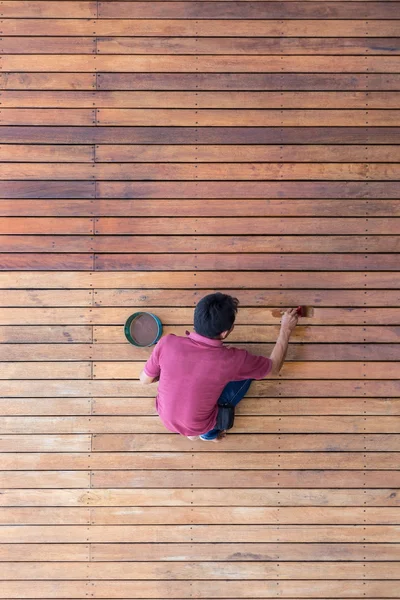 A man painting exterior wooden pool deck, Top view — Stock Photo, Image