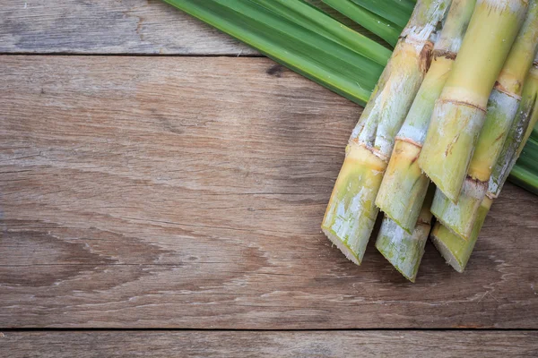 Vista superior cana-de-açúcar fresca e folha em madeira — Fotografia de Stock