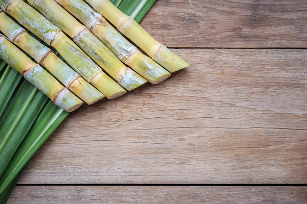 Bovenaanzicht verse suikerriet en leaf op houten — Stockfoto