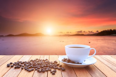 Beyaz kahve fincanı ve ahşap masa ve görünümü Güneşlerin kahve çekirdekleri