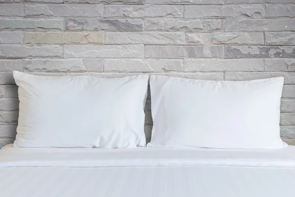Белые простыни и подушки в номере отеля — стоковое фото